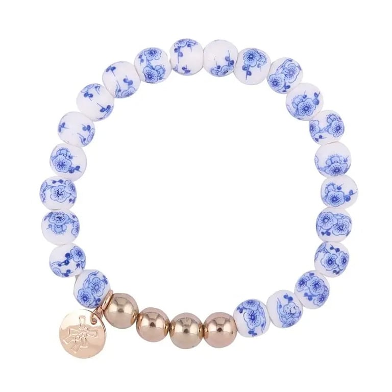 Armbånd med hvide perler dekoreret med blå blomster og fire metalperler i rosaguld med en rund vedhæng i rosaguld.