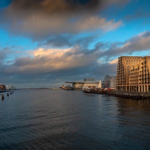 lav sol over Københavns havn en smuk vinteraften med Papirøen til højre og Skuespilhuset til venstre samt Operaen i baggrunden   – produktbillede