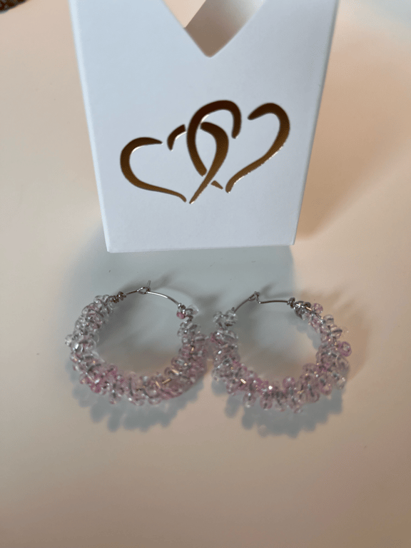 Meget lyserøde glasperler snoet omkring creolerne