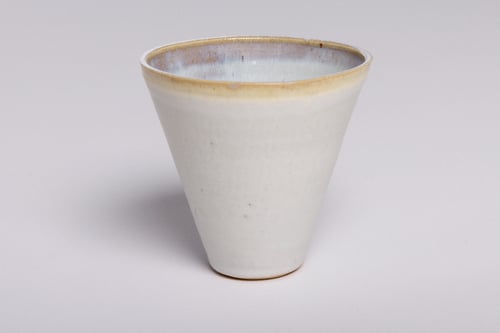 Keramisk, hvid kegleformet kop med let blå og gul kant.