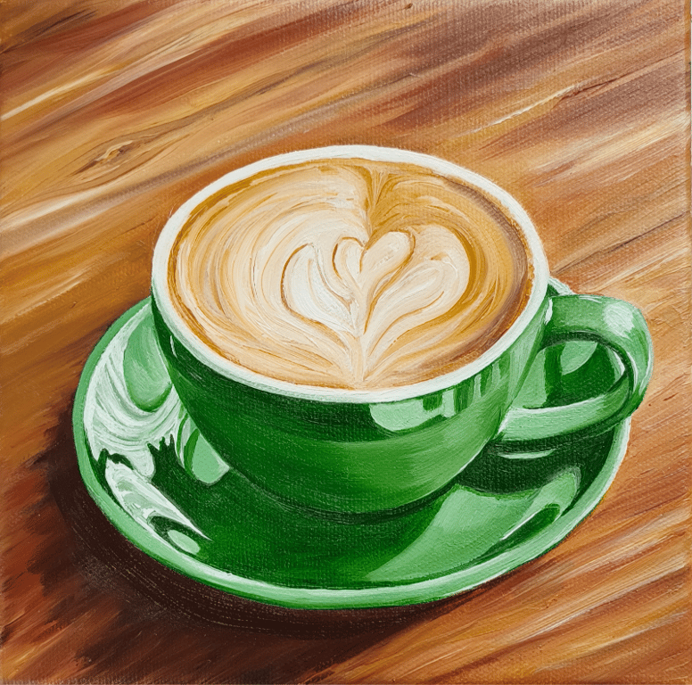 Cappuccino i grøn kop på træbord 