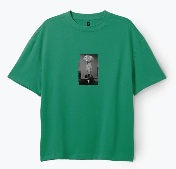 Grøn T-shirt med sort-hvidt tryk af en person i jakkesæt med et stort skyer af røg eller eksplosion over hovedet.