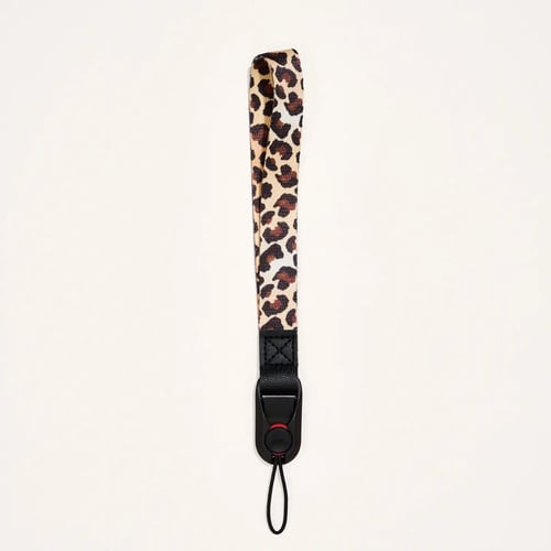 Nøglesnor med leopardmønster og sort hæfteclip mod en lysegrå baggrund. (1)
