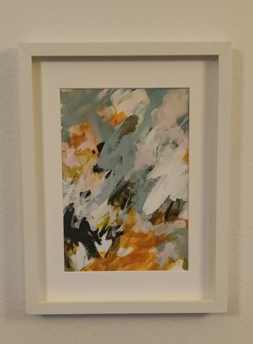 Abstrakt maleri i hvid ramme med farverne orange, sort, hvid og grå i en blandet tekstur og mønster. (1)