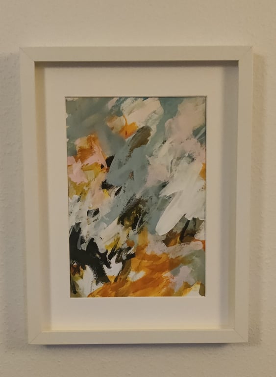 Abstrakt maleri i hvid ramme med farverne orange, sort, hvid og grå i en blandet tekstur og mønster.