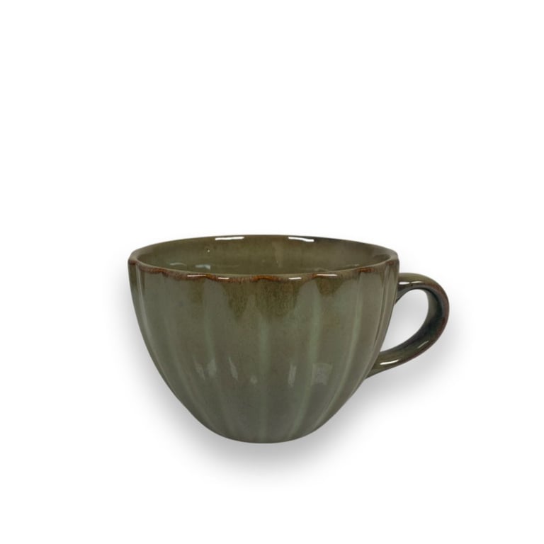 Grøn glaseret keramisk kop med bølgede sider og hank mod højre på hvid baggrund.