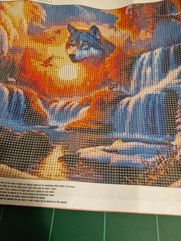 Broderi- eller diamantmaleri kit med motiv af en ulvshoved over vandfald ved solnedgang, med forskellige symboler på lærredet til guide.