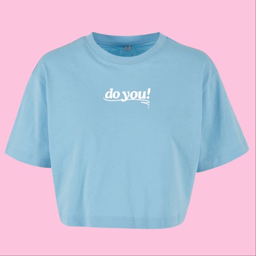 Lyseblå cropped T-shirt med hvid tekst "do you!" på brystet mod lyserød baggrund. (1)