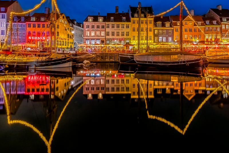 Billedet er taget Nyhavn i København under den fortryllende lysfestival, hvor hele området oplyses med smukke farver og levende lys.