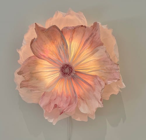 Blomstervendt væglampe i bløde rosa og cremefarver med oplyste kronblade. (1)