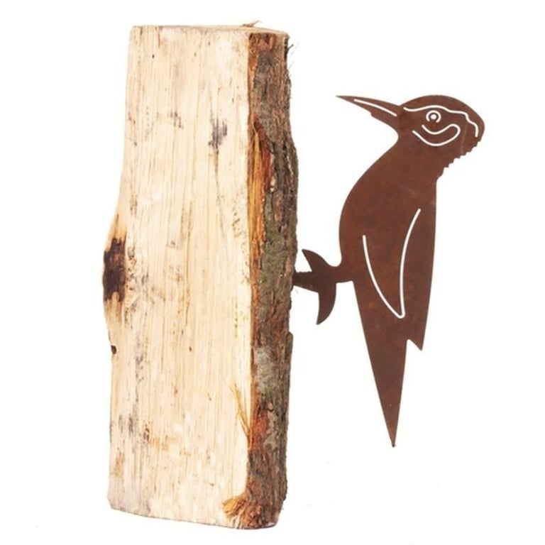 Rustfarvet metalfigurmål af en spætte siddende på en stykke træstykke med bark.