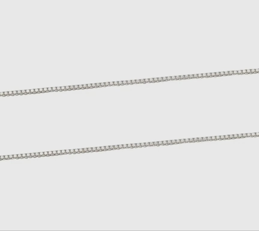 Sølvfarvet kassekæde på ensfarvet baggrund. (2)