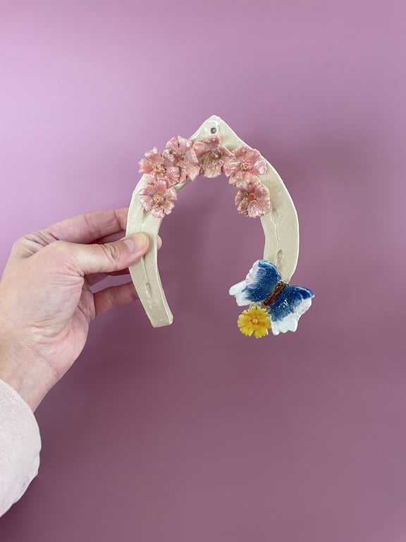 Håndformet hestesko med sommerfugl og blomster