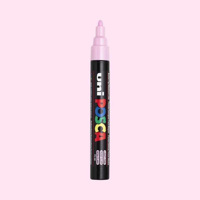 Posca tusch i sort med farvet logo og lys pink spids mod lyserød baggrund.
