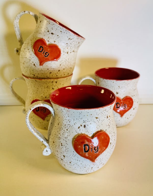 Fire beige keramikkrus med rødt hjerte og ordet "Dig" på forsiden, rød inderside.