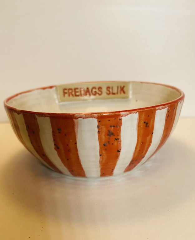 Skål med orange og hvide striber med tekst "FREDAGS SLIK" indvendigt.