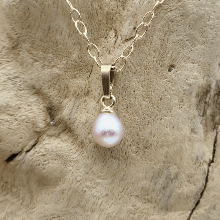 Rosa guldbelagt vedhæng.