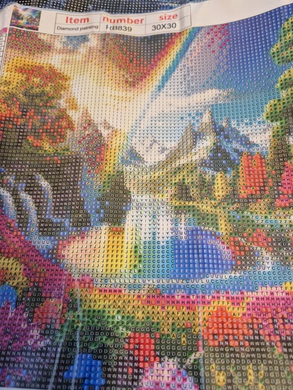 Et farverigt diamantmaleri med et eventyrligt slot, regnbue og landskab, markeret med symboler for at angive diamantfarver, i størrelsen 30x30 cm.