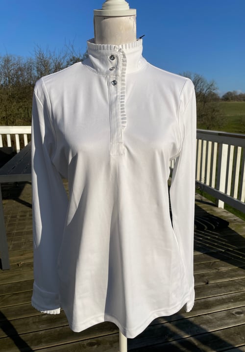 Hvid langærmet skjorte med høj krave og knapper på fronten, vist på en mannequin udendørs på en terrasse. (1)