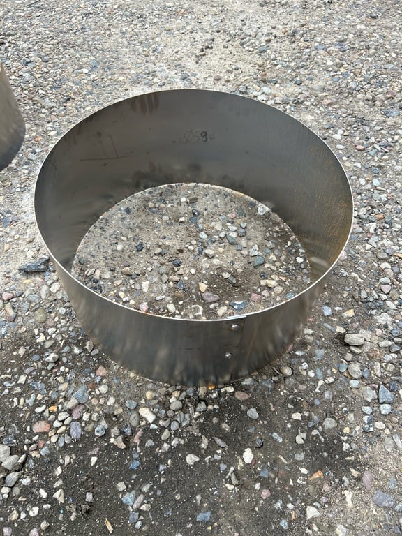 Rustfri stål ring placeret på gruset jordbund.