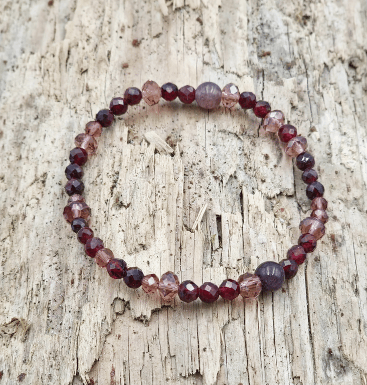 Vinrødt og lyserødt armbånd.
