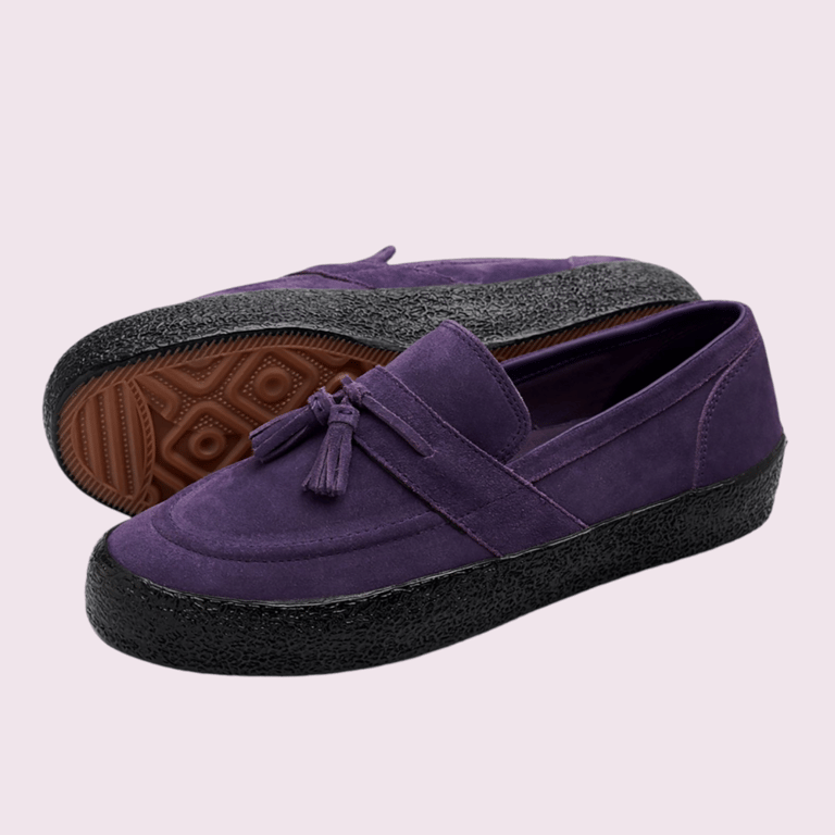 Lilla loaferssko i ruskind med sort grov sål og dekorative kvaster på oversiden.