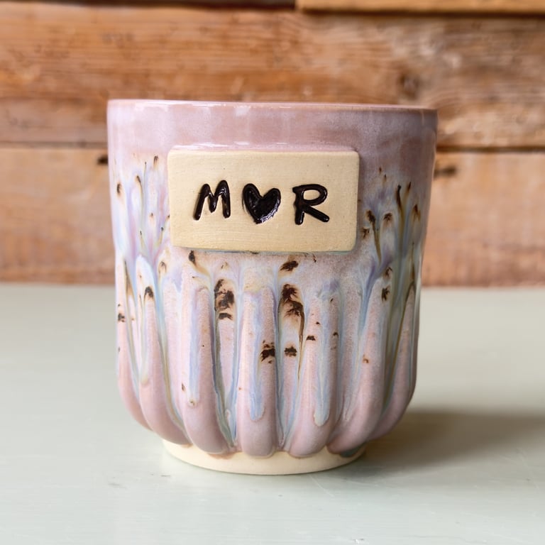 Keramikkop med glaseret finish i lyserøde og blå nuancer, med skilt hvor der står "M♥R".