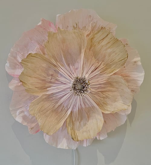 Stor, cremefarvet og rosa kunstig blomst med detaljerede kronblade mod en lys baggrund. (1)