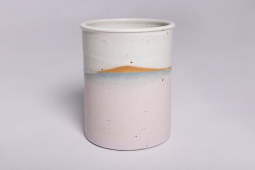 Keramisk krus med glaseret overflade i hvid, blå og lyserød med brune pletter.