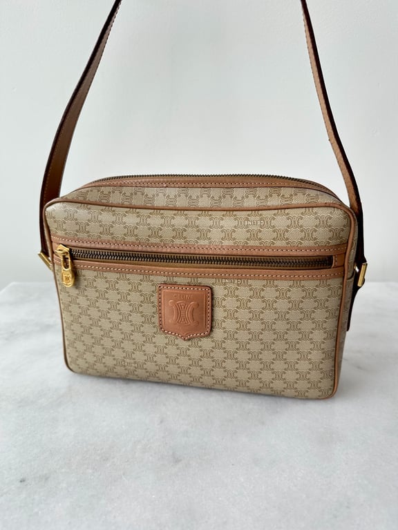 Beige og brunt Celine skuldertaske med mønstret design og guld lynlåsdetalje, placeret på hvid overflade.