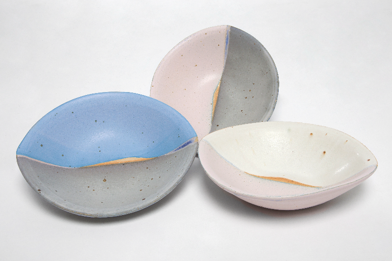 Tre farvede, knuste skåle i pastelnuancer står på en hvid baggrund.