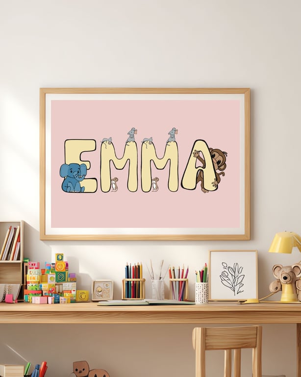 Børneværelse med skrivebord, farveblyanter, byggeklodser og en indrammet plakat på væggen med navnet "EMMA" pyntet med illustrationer af elefanter, mus og en abe på en lyserød baggrund.