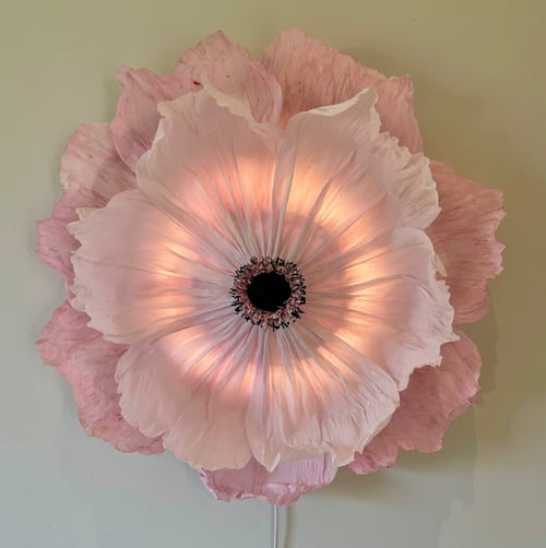 Stor, lysende pink blomst formet lampe hængende på væggen. (1)