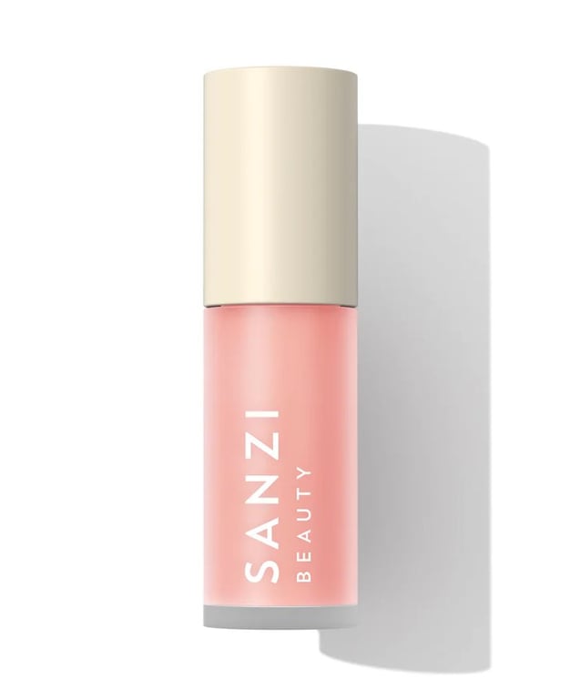 Flaske med rosa Sanzi Beauty kosmetikprodukter med beige låg på hvid baggrund.