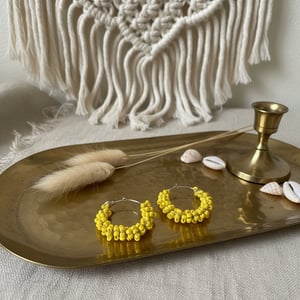 Gule perler snoet om creolen – produktbillede