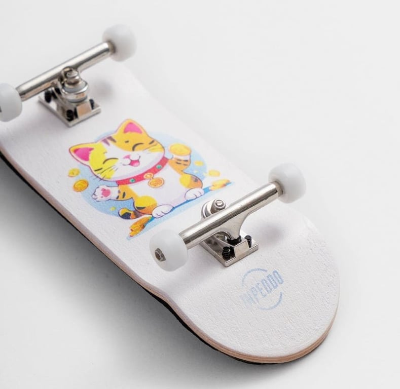 Hvid fingerboard med en tegning af en lykkelig kat omgivet af guldmønter på overfladen.