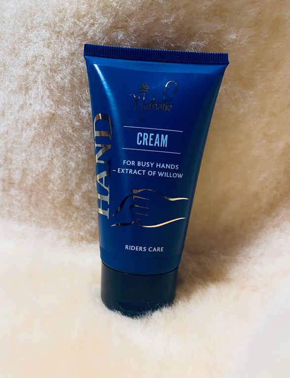 Blå tube med håndcreme mærket "HAND CREAM for busy hands - extract of willow" fra Riders Care, placeret på blødt, lyst stof.