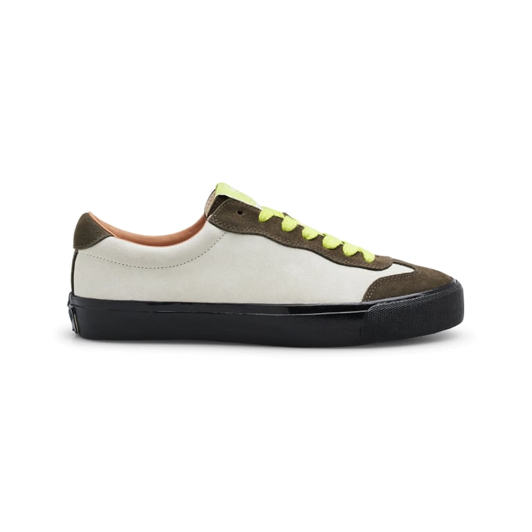 Hvid og olivengrøn sneaker med sort sål og gule snørebånd set fra siden på hvid baggrund.