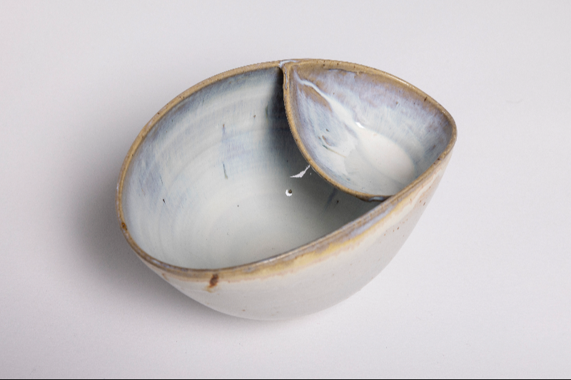 Keramisk skål med en mindre integreret sektion, hvid og blå glasur med brun kant.