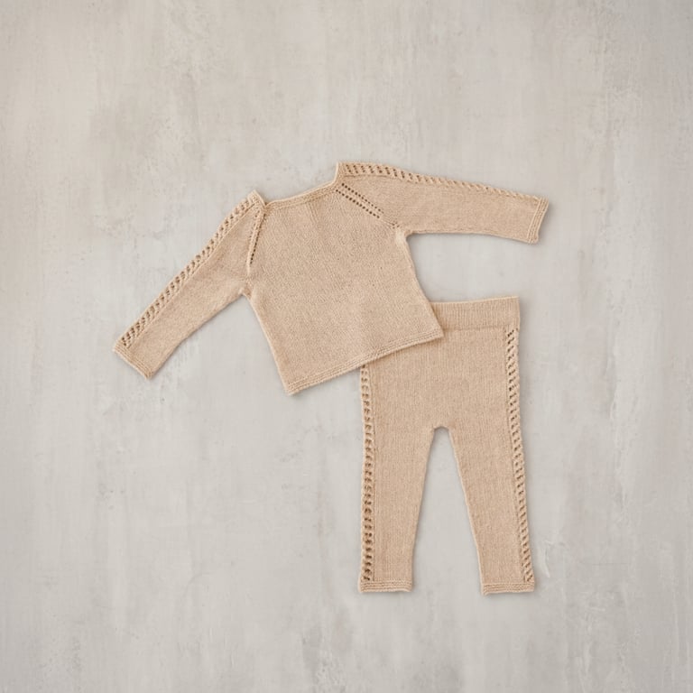 Striktrøje og bukser i beige uld til baby med hulmønster langs ærmer og ben.